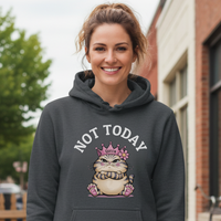 Load image into Gallery viewer, Woman wearing a hoodie with a graphic design and text, standing on a sidewalk.