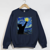 Load image into Gallery viewer, Navy blue sweatshirt with a graphic of a hand reaching towards a stylized night sky design on a hanger.