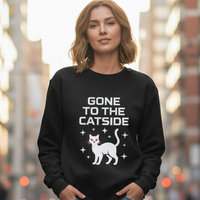 Load image into Gallery viewer, Person wearing a black sweatshirt with &#39;Gone to the Catside&#39; text and cat graphic in an urban setting
